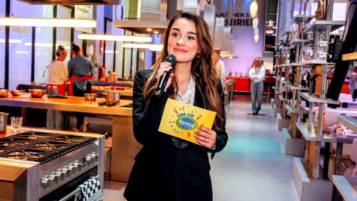 Esther presenteert met microfoon in een keukenstudio
